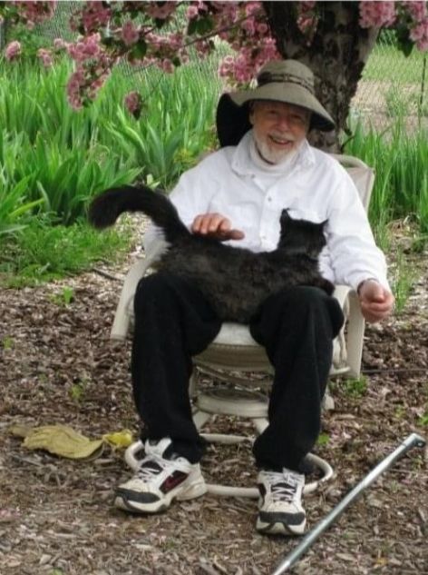 Gene Washington sitting with a cat on his lap.