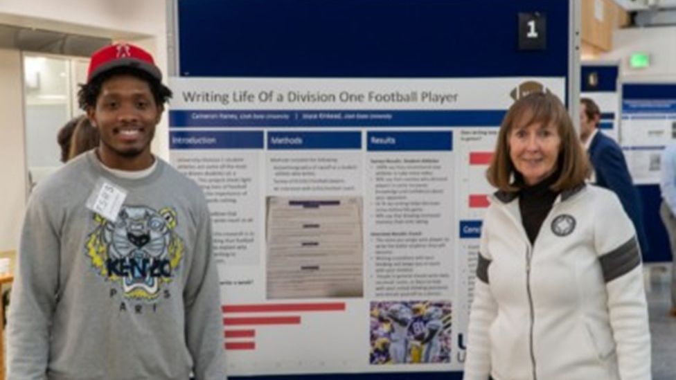 Cameron Haney and Dr. Kinkead standing in front of a presentation poster.
