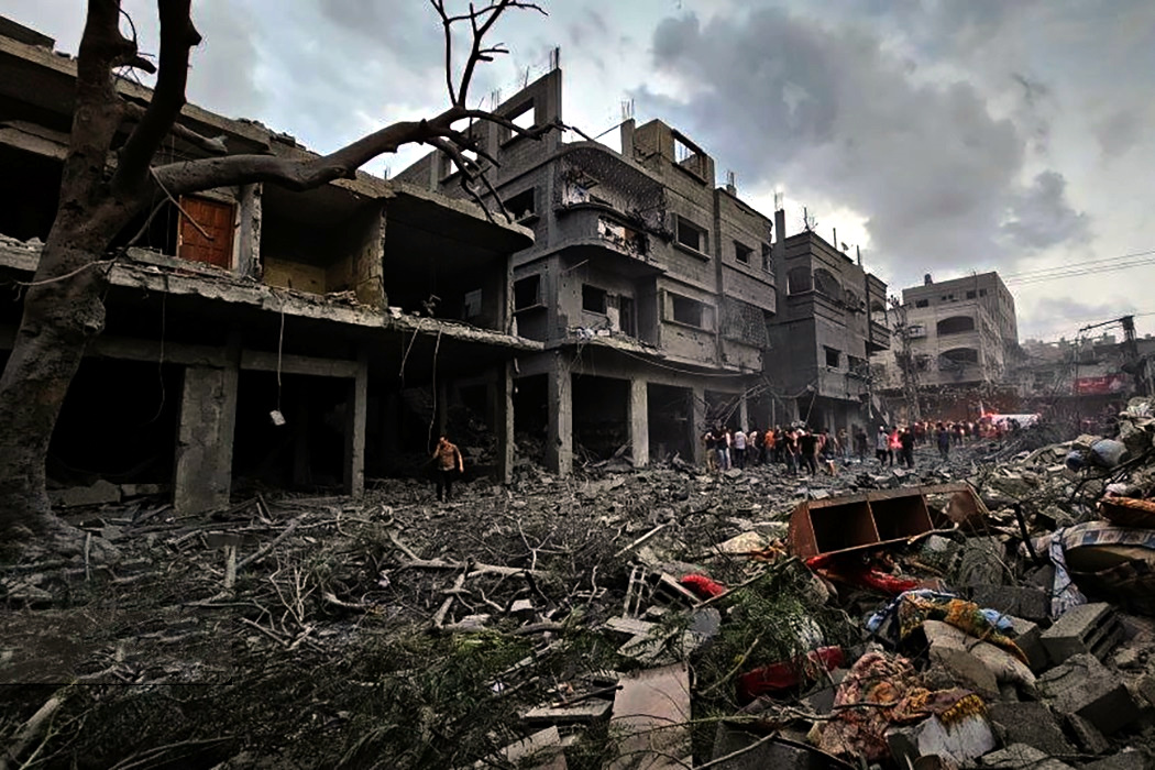 Destruction of a city on the Gaza Strip during 2023. Building rubble with the remants of a few buildings remain in dim light.