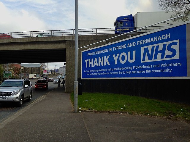 A billboard featuring a sign thanking the NHS for its service off of a highway in Northern Ireland.