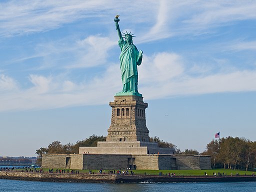 The Statue of Liberty on a clear sunny day during the summer looking towards the ocean.
