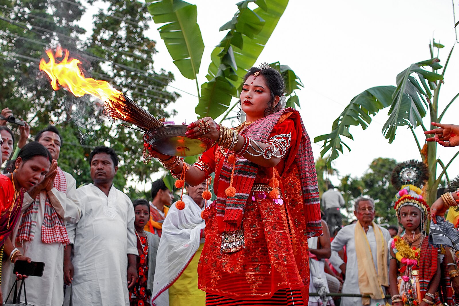 Woman performing with incense and fire on a street during a festival in Bangladesh.